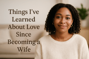 Smiling African American woman in a cream sweater sitting in a cozy living room — Christian wife reflecting on love and marriage.