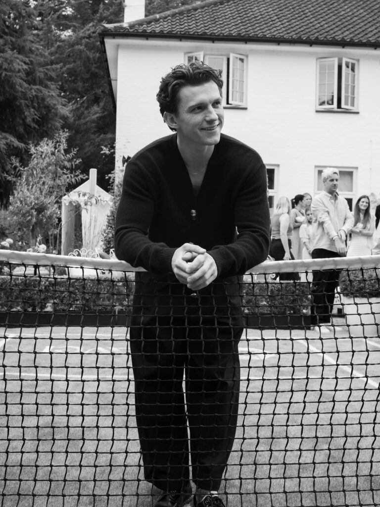 Black and white picture of Tom Holland in a black outfit.