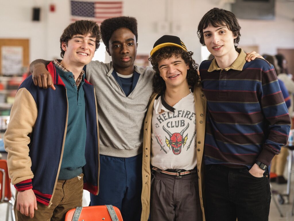 A group of teenagers standing together and smiling, representing friendship and unity in Stranger Things