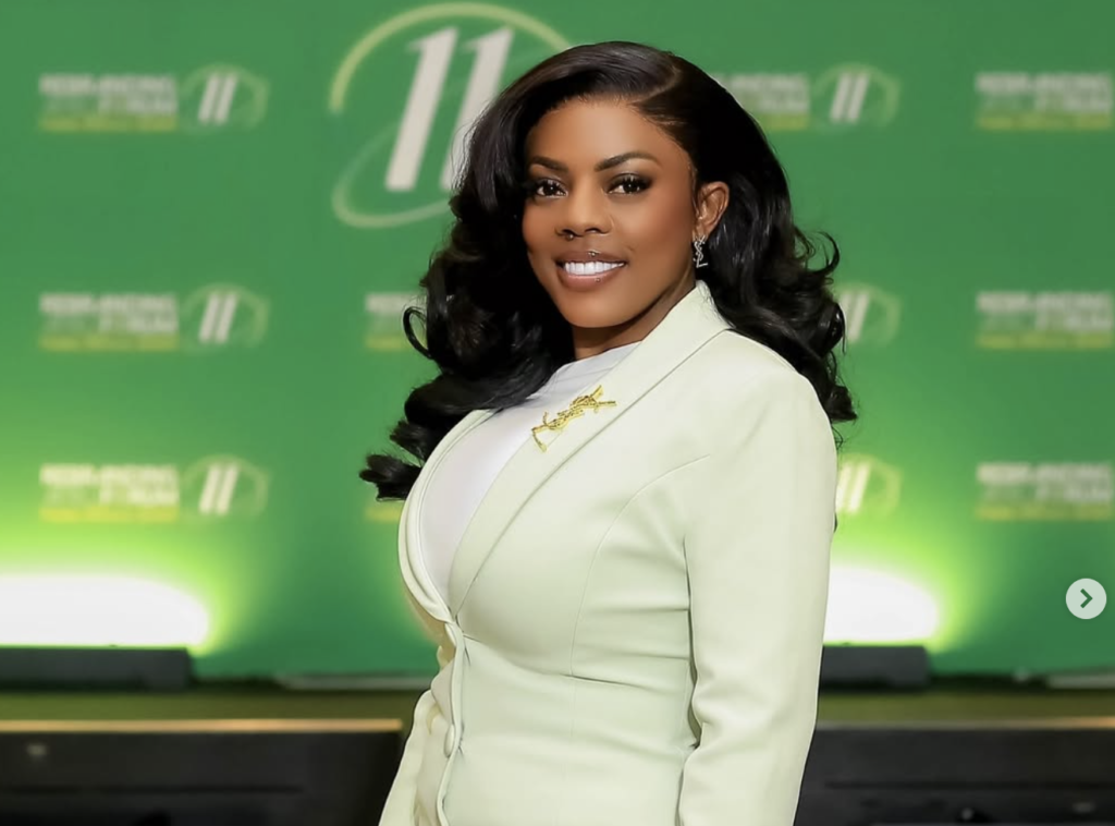 Nana Aba Anamoah smiling confidently in a mint green blazer dress at a high-profile public event.