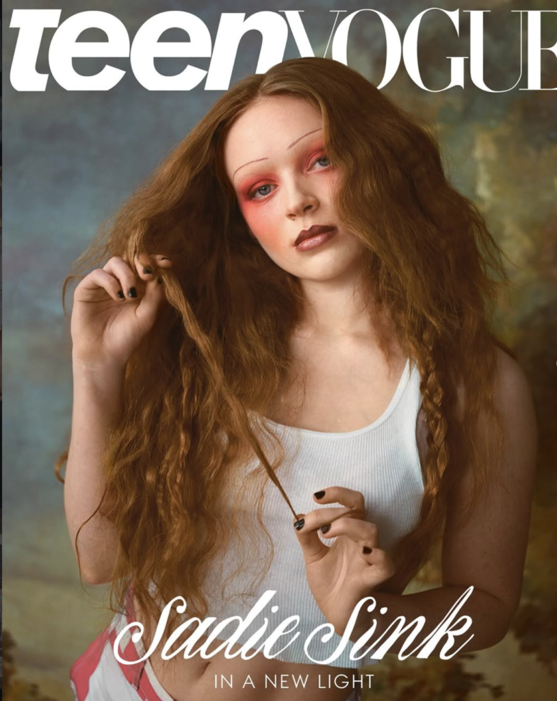 Red-haired actress with dramatic editorial makeup and long textured hair in magazine-style photoshoot