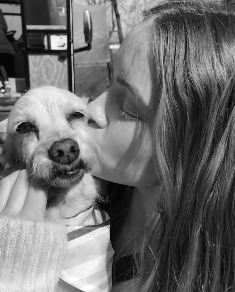 Sadie kissing small dog affectionately in black and white candid moment