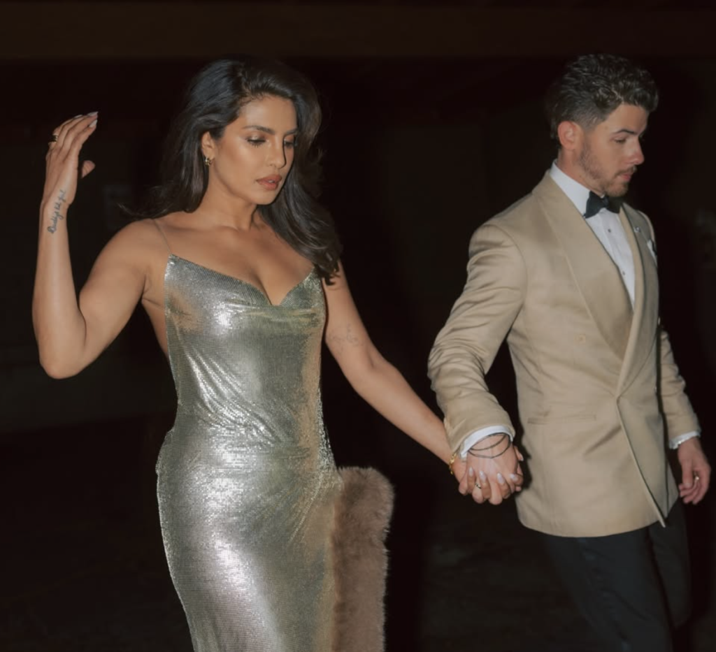 Priyanka Chopra and Nick Jonas holding hands at an event in elegant outfits