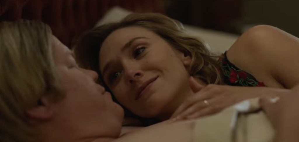 A man and woman lying closely together in bed during an intimate and emotional moment in Love & Death.