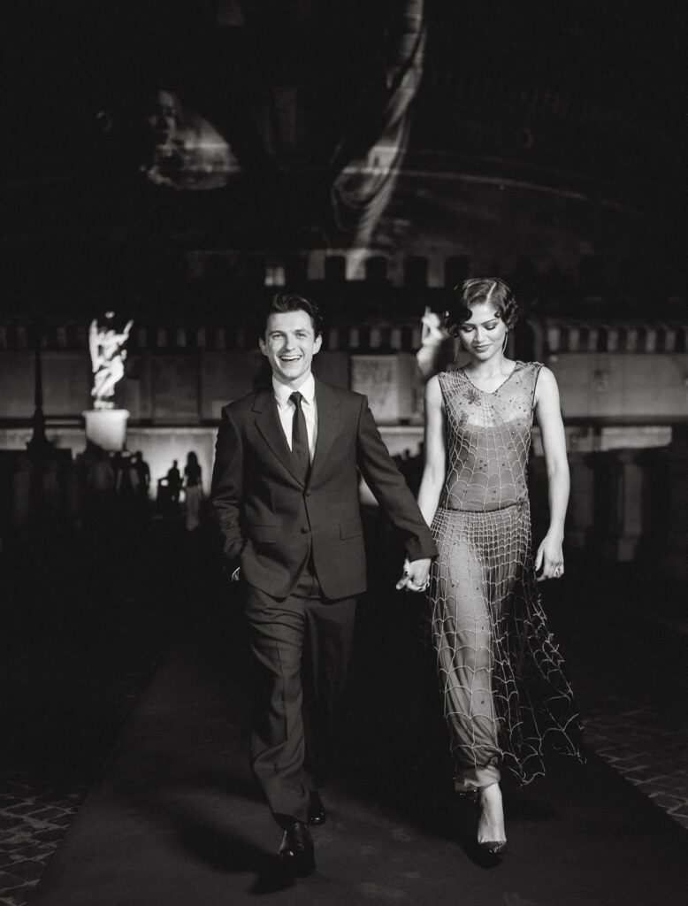 Tom Holland and Zendaya hold hands while walking together during the Spider-Man: Brand New Day press tour.