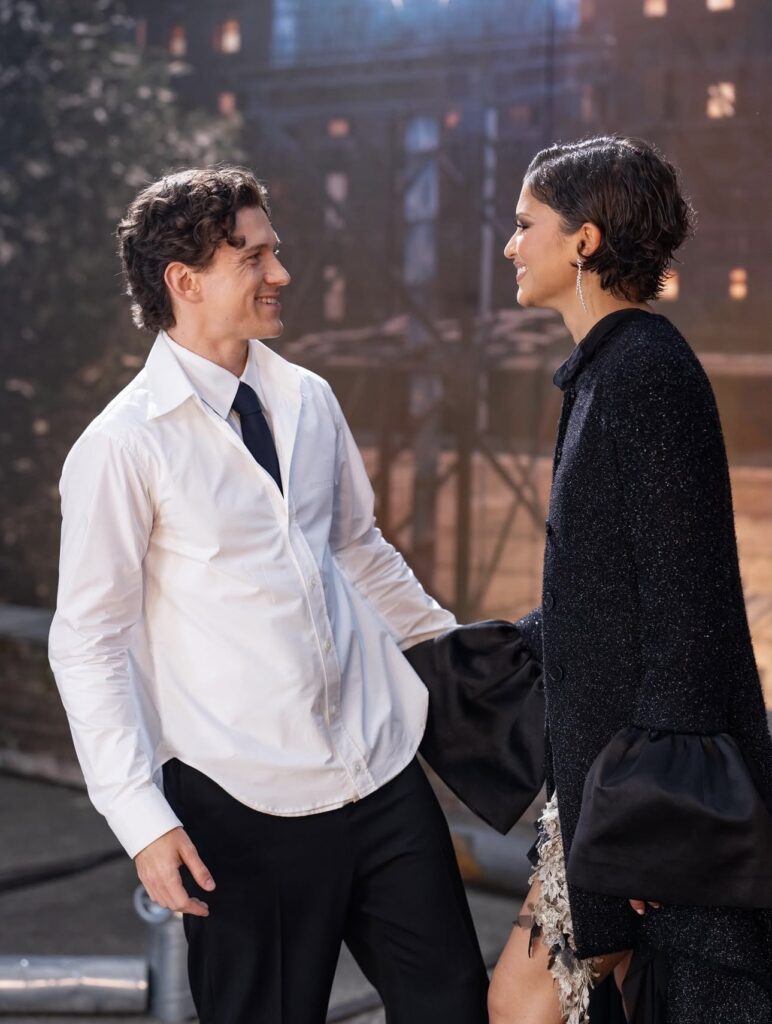 Tom Holland and Zendaya smile at each other while holding hands during the Spider-Man: Brand New Day press tour.