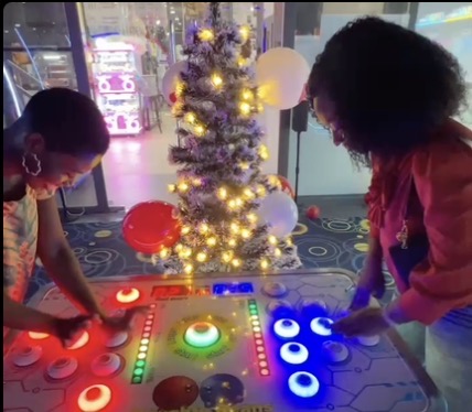 Two Ghanaian female friends playing games at a game centre in Atlantic Mall. fun things to do with friends in Accra
