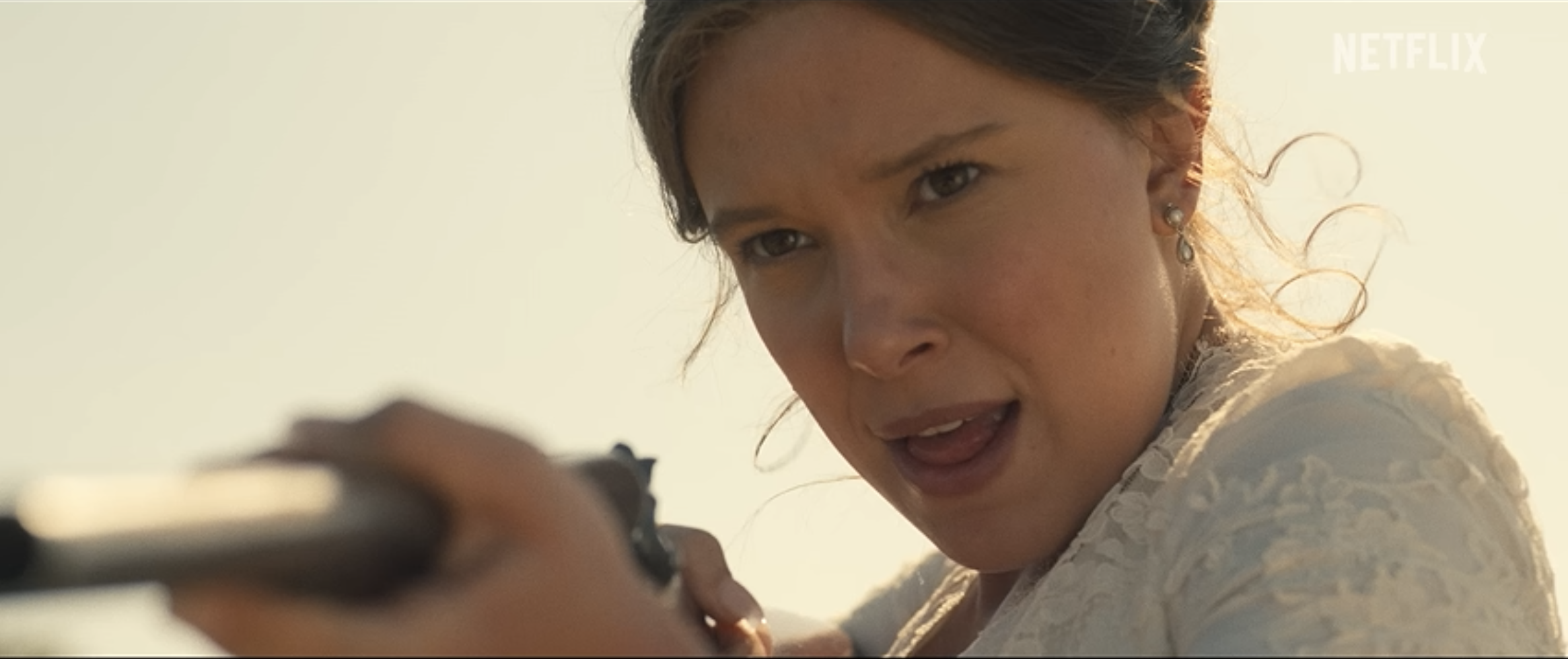 Enola Holmes aims a rifle during an action scene in Enola Holmes 3 on Netflix.