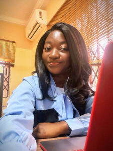 Young Ghanaian woman sitting at her desk on her first day at work.